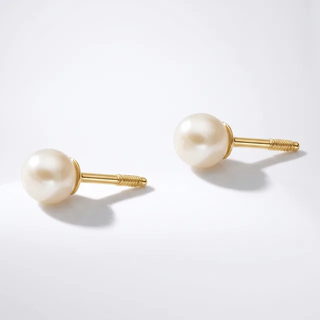 A pair of gold stud earrings with cream-colored pearl tops and threaded posts, displayed on a light gray background.