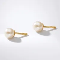 A pair of gold stud earrings with cream-colored pearl tops and threaded posts, displayed on a light gray background.
