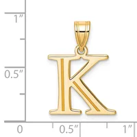 Gold letter K pendant with a polished finish and bail loop, shown next to a ruler indicating approximately one inch in height.