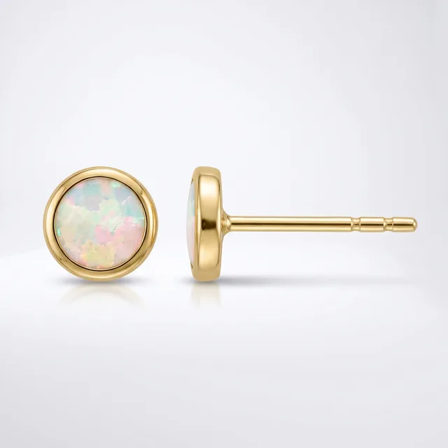 A pair of gold stud earrings with round opal stones set in bezel settings, shown from front and side views against a white background.