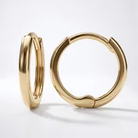 A pair of polished gold hoop earrings with a chunky, rounded profile and hinged closure, displayed against a white background.