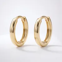 A pair of polished gold hoop earrings with a chunky, rounded profile and hinged closures, displayed against a white background.