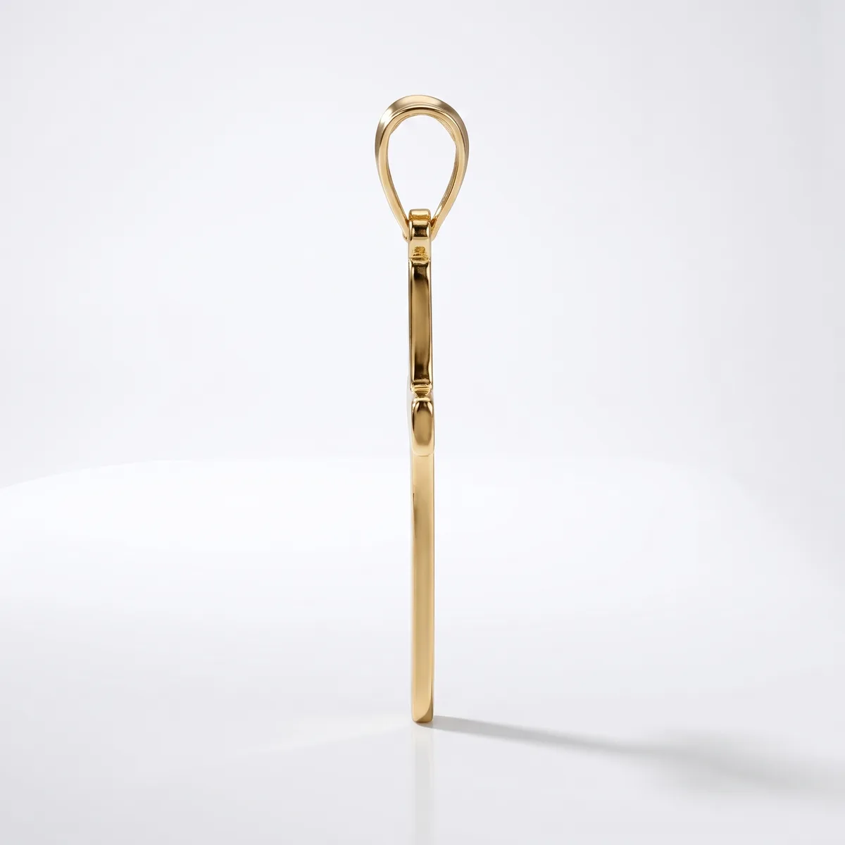 A polished brass shoehorn with an elongated handle and a teardrop-shaped loop at the top, shown standing upright against a white background.