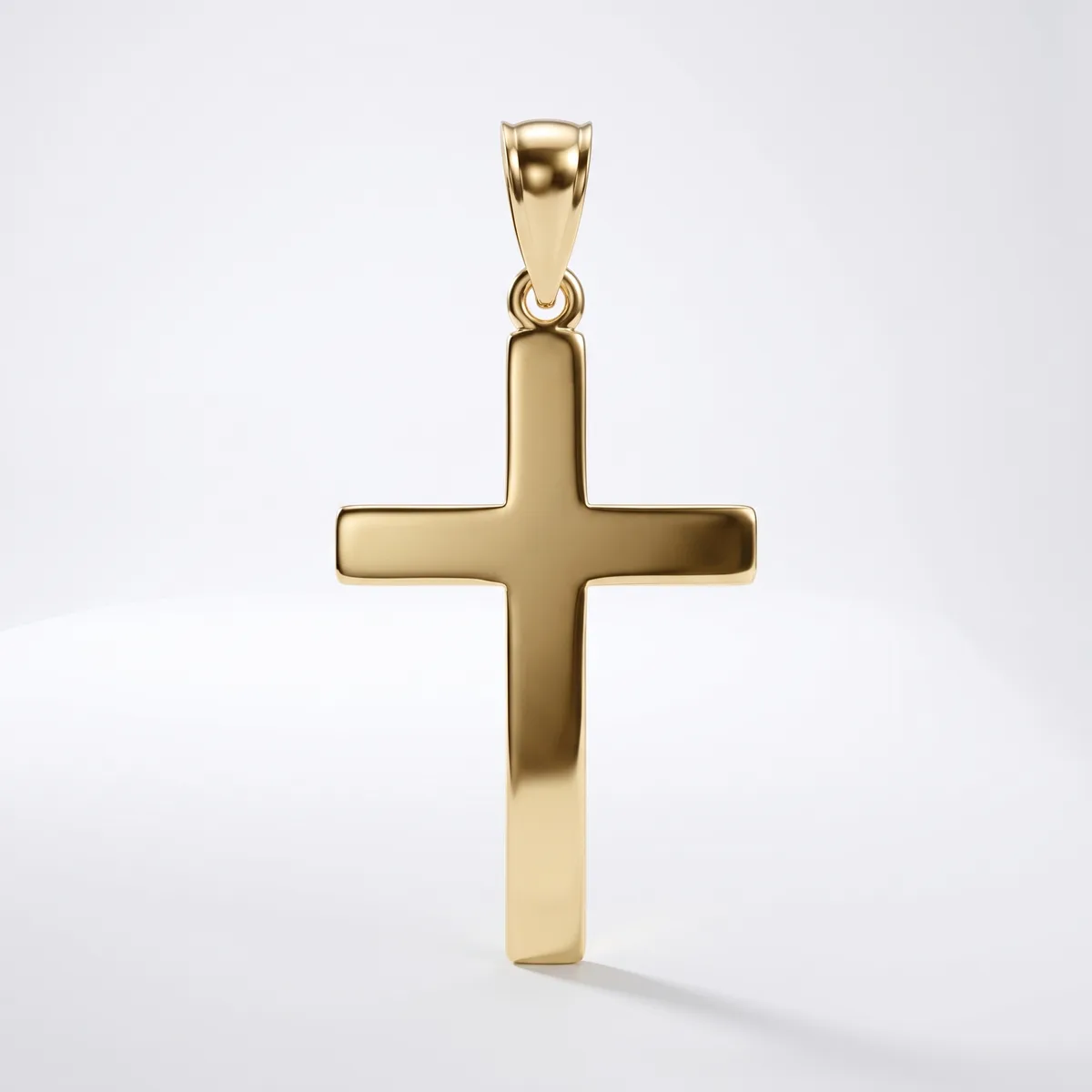 A polished gold cross pendant with a rectangular bail loop at the top, displayed against a white background with a soft shadow beneath it.