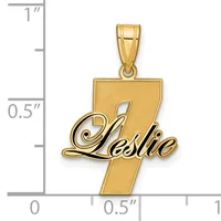 Gold pendant featuring the number 7 with the name Leslie in script overlaid, shown against a ruler for scale.