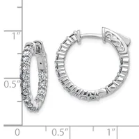 A pair of silver hoop earrings with diamond accents shown next to a ruler measuring approximately one inch in length.