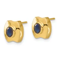 A pair of gold stud earrings with polished curved rectangular frames each set with an oval dark blue stone, shown from the front.