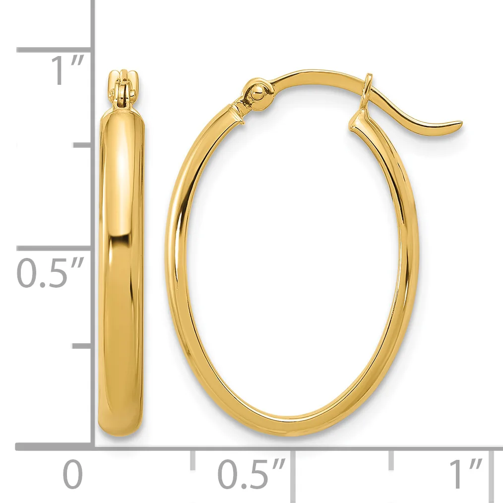 A pair of polished gold oval hoop earrings with hook closures displayed next to a measurement scale showing approximately one inch in height and half inch in width.