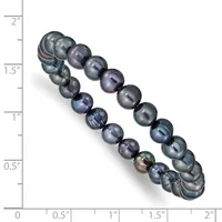 Two strands of dark gray and black pearl beads of varying sizes arranged diagonally against a measurement scale showing heights from 0 to 2 inches.