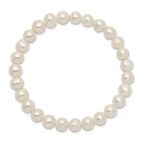 A stretchy bracelet strung with uniformly sized cream-colored pearl beads arranged in a complete circle against a white background.