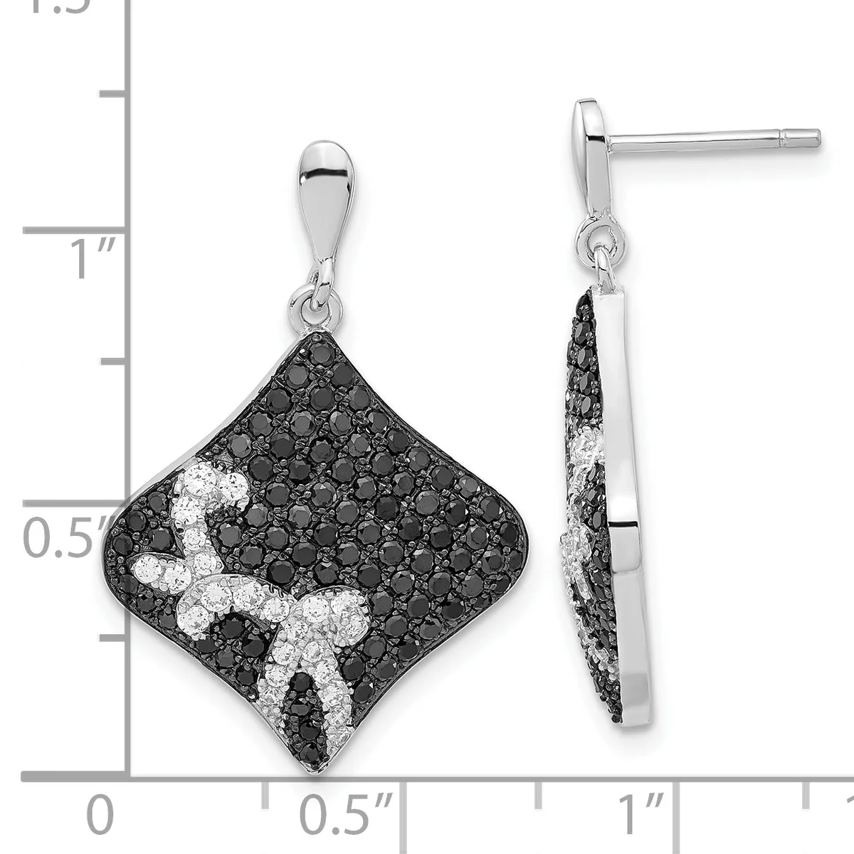 A pair of diamond-shaped drop earrings with black and white gemstones arranged in a curved pattern, shown next to a measurement ruler.