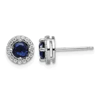 Pair of silver stud earrings with round dark blue sapphires surrounded by small diamonds, shown from front and side views.