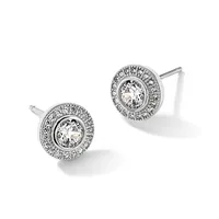 A pair of round diamond stud earrings with a central clear stone surrounded by a halo of smaller diamonds set in white metal, shown from the front.