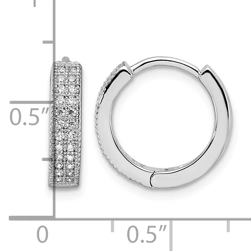 A pair of silver hoop earrings with pave diamond settings shown against a measurement scale indicating they are approximately 0.5 inches in diameter.