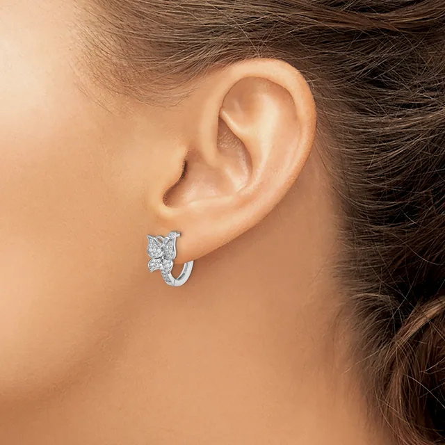 A woman wearing a small silver hoop earring with a rectangular diamond or crystal stone accent, shown from the side view of her ear.