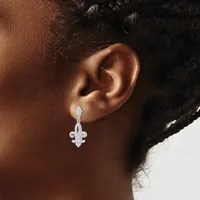 A person wearing a silver fleur-de-lis pendant earring with diamond or crystal accents, shown from the side profile against a neutral background.