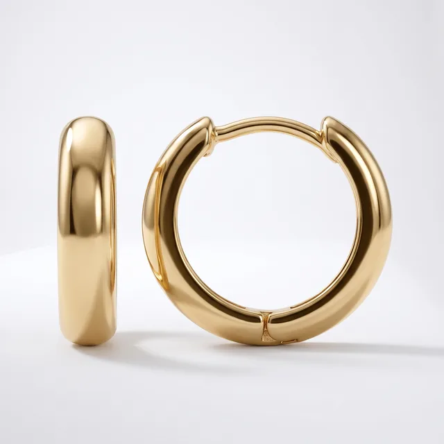A pair of polished gold-toned chunky hoop earrings with a smooth, rounded profile displayed against a white background.