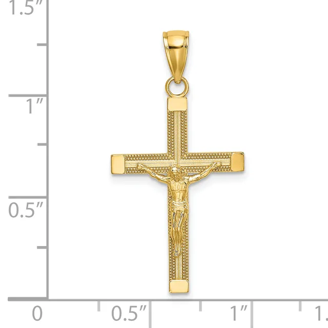Gold crucifix pendant with textured surface and figure of Jesus Christ, shown next to a ruler measuring approximately 1.25 inches tall.