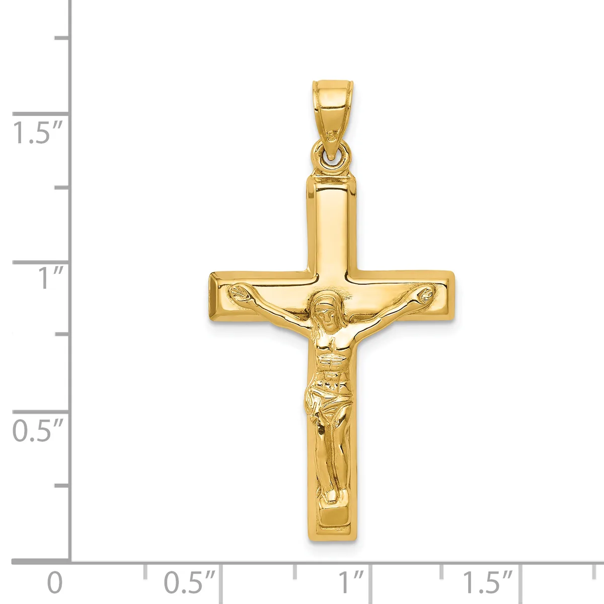 Gold crucifix pendant with detailed corpus figure, shown next to a ruler indicating approximately 1.5 inches in height.
