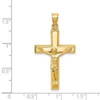 Gold crucifix pendant with detailed corpus figure, shown next to a ruler indicating approximately 1.5 inches in height.