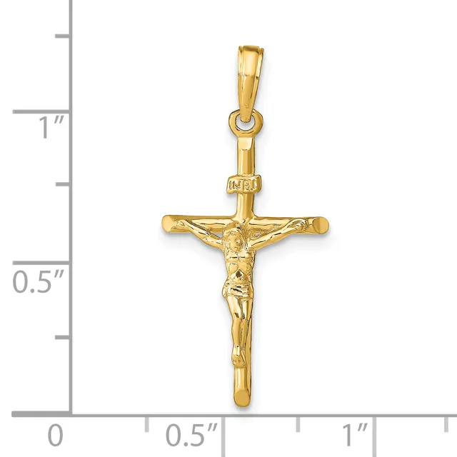A polished gold crucifix pendant with a figure of Christ depicted on the cross, shown against a ruler indicating approximately one inch in height.