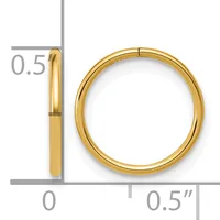 A polished gold-colored circular bangle bracelet shown next to a ruler indicating its dimensions of approximately 0.5 inches in width and diameter.