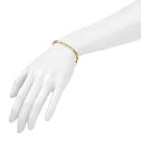 A gold-toned bamboo-style link bracelet worn on a white mannequin hand against a white background.