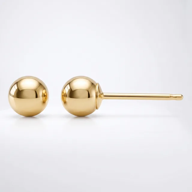 A pair of polished yellow gold ball stud earrings with thin posts displayed against a white background.