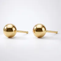 A pair of polished gold sphere stud earrings with posts and backs, displayed on a white background.