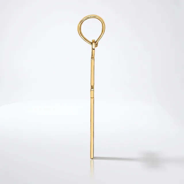 A long, slender brass or gold-toned metal tool with a circular loop at the top and a straight shaft with subtle segmented details, photographed against a white background.