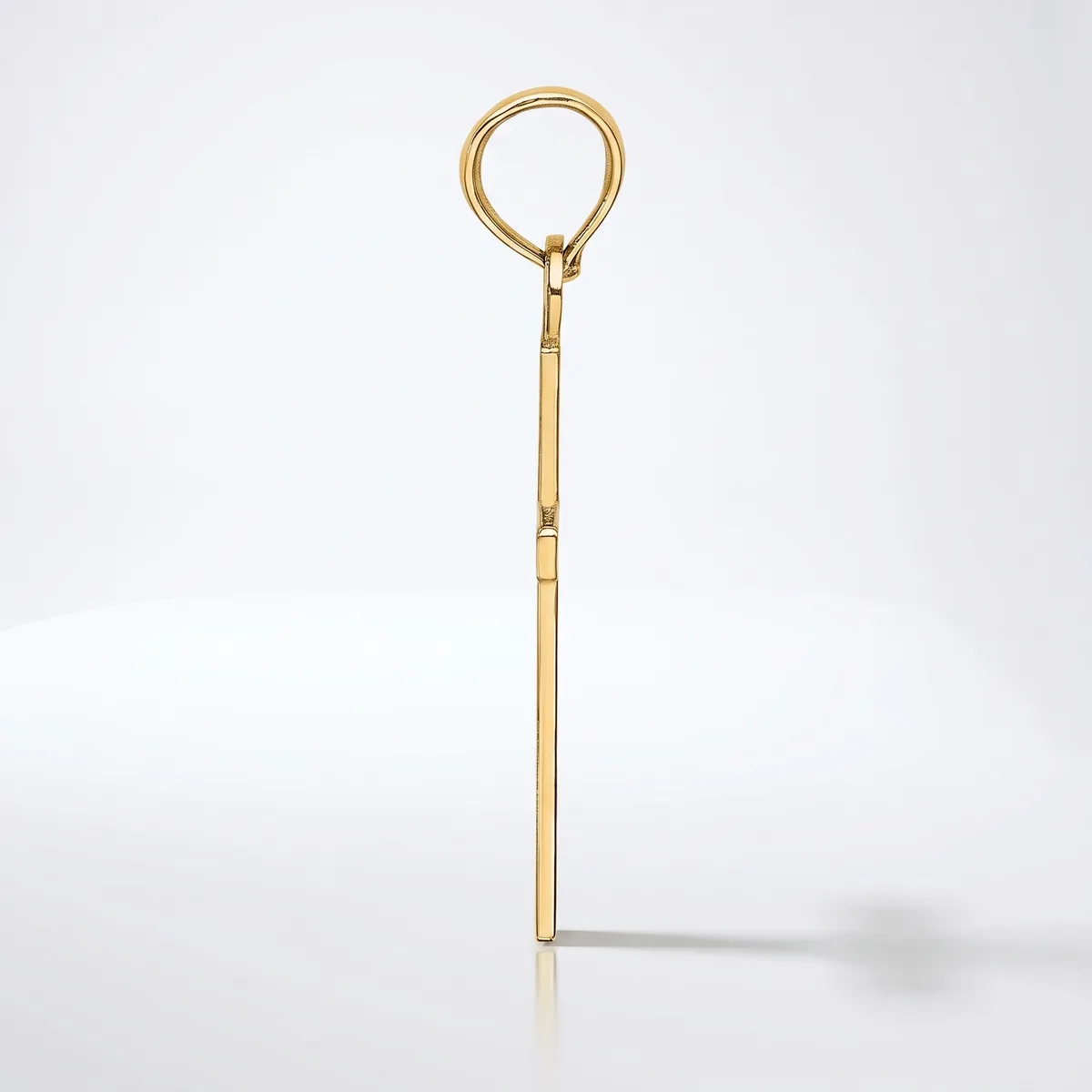 A long, slender brass or gold-toned metal tool with a circular loop at the top and a straight shaft with subtle segmented details, photographed against a white background.