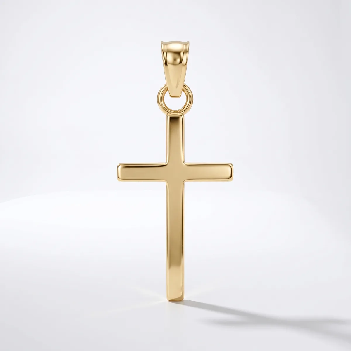 A polished gold cross pendant with a rectangular design and rounded edges, suspended from a matching bail, displayed against a white background.