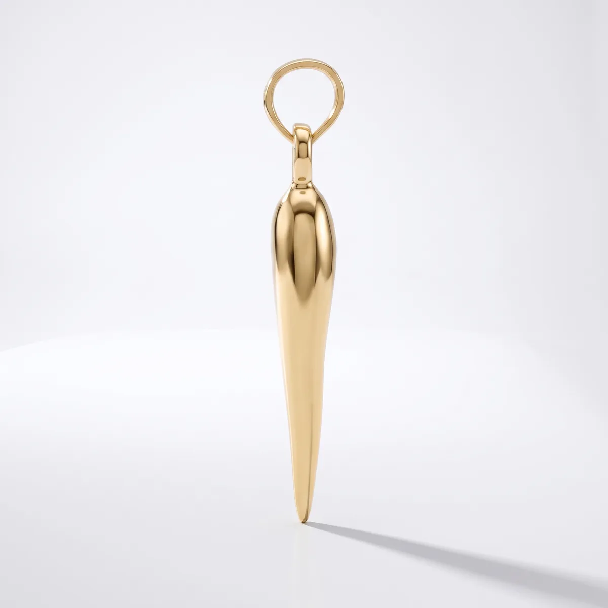 A polished gold-toned pendant in an elongated tapered shape with a rounded top, suspended from a matching ring loop against a white background.