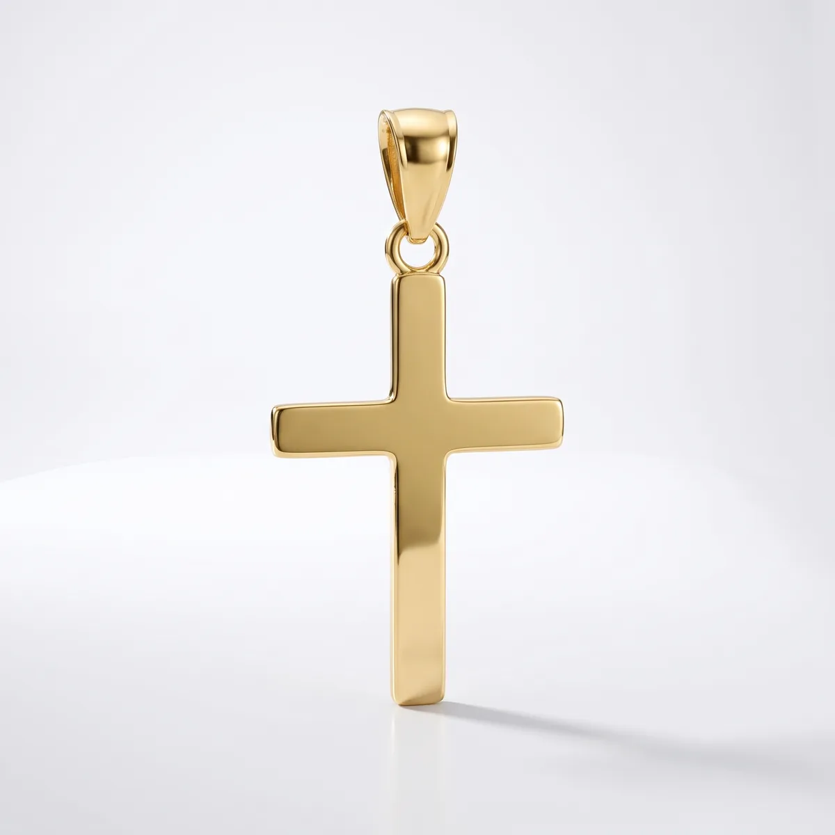 A polished gold cross pendant with a rectangular shape and small bail loop at the top, displayed against a white background.