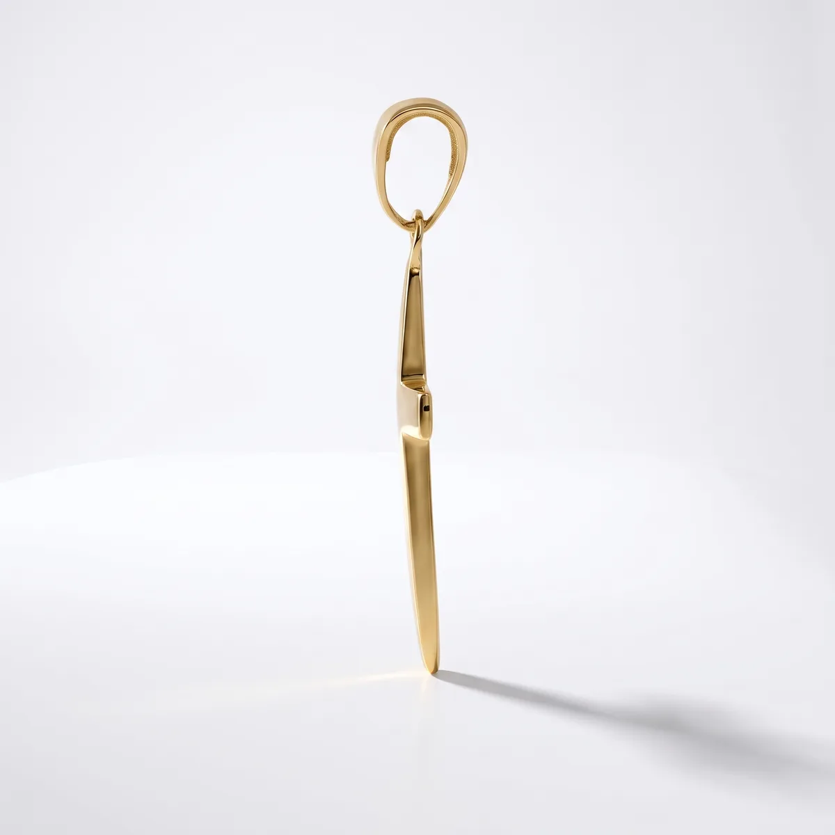 A gold-toned metal shoehorn with an oval loop handle at the top and a flat, tapered blade, displayed standing upright against a white background.