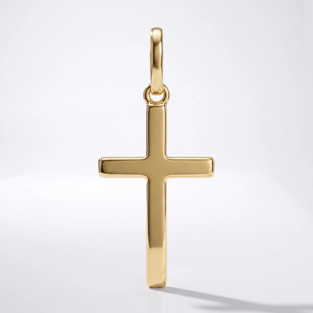 A polished gold cross pendant with a looped bail at the top, displayed against a white background.