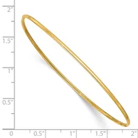 A polished gold-toned oval bangle bracelet with a slightly tapered design, shown next to a ruler indicating it measures approximately 2 inches in length.