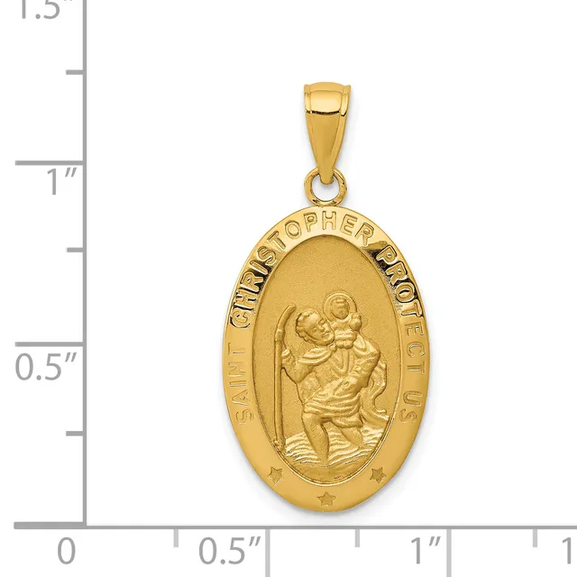 Gold oval pendant featuring Saint Christopher carrying the Christ child, with text around the border, shown next to a ruler measuring approximately 1.25 inches in height.