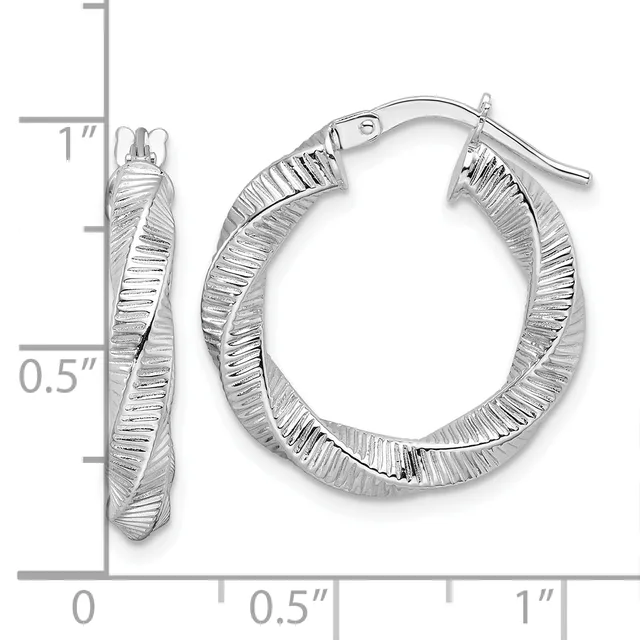 Pair of silver twisted hoop earrings with textured surface and post backs, shown next to a ruler measuring approximately one inch in diameter.