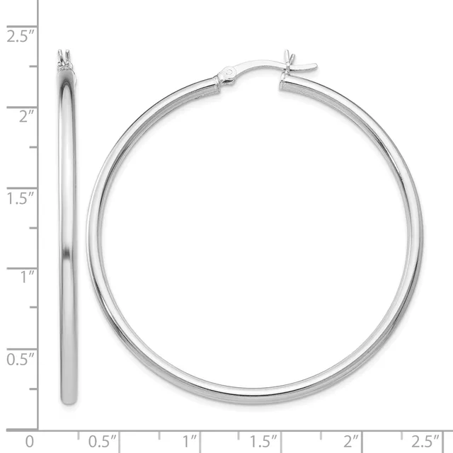 A pair of silver hoop earrings with a polished finish and small posts with friction backs, shown next to a measurement scale.