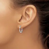 A woman wearing a small textured silver hoop earring in her earlobe, shown in close-up profile view.