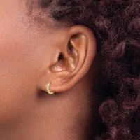 Close-up of a person's ear wearing a small gold hoop earring set with white stones on the lower arc.