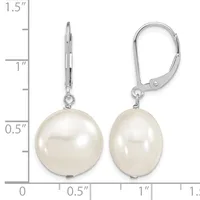 A pair of white pearl drop earrings with silver lever-back closures displayed next to a ruler showing approximately 1.25 inches in length.