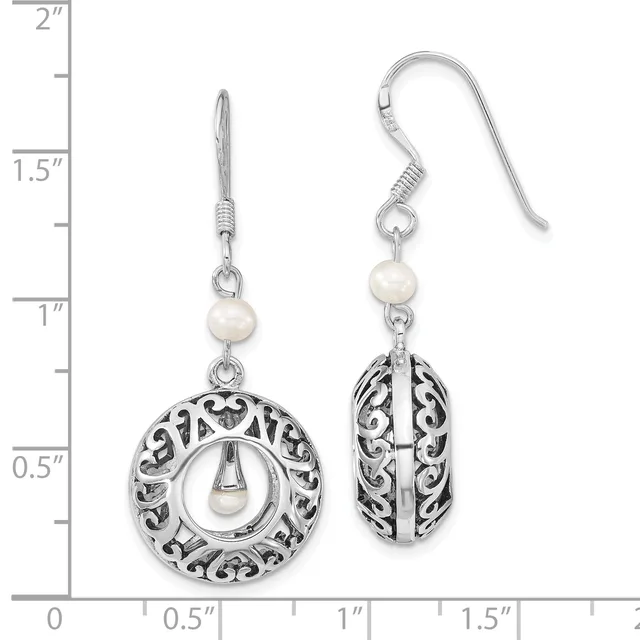 Pair of silver filigree earrings with pearl accents, featuring circular and oval openwork designs, displayed on a measurement scale showing approximately 1.5 inches in length.