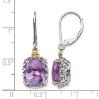 A pair of silver and gold dangle earrings with oval purple amethyst stones surrounded by ornate metalwork, shown front and back against a measurement scale.