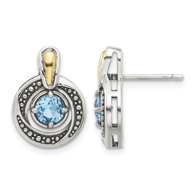 Pair of two-tone stud earrings featuring round light blue gemstones surrounded by beaded silver frames with gold-tone accents, shown from front and side views.