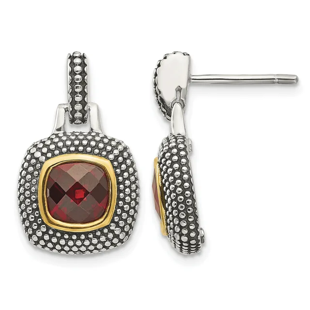 Pair of silver and gold drop earrings with cushion-cut red gemstones surrounded by beaded metalwork, shown from front and side views.