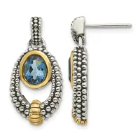 Two silver and gold two-tone drop earrings with beaded detailing and oval blue gemstones in gold bezels, shown from front and side views.