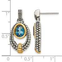 Pair of two-tone drop earrings featuring oval blue topaz stones set in gold bezels, surrounded by beaded silver frames and gold accents, shown against a measurement scale.
