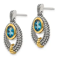 Pair of two-tone drop earrings with blue oval gemstones set in gold bezels, surrounded by beaded silver frames and gold accents at the base.